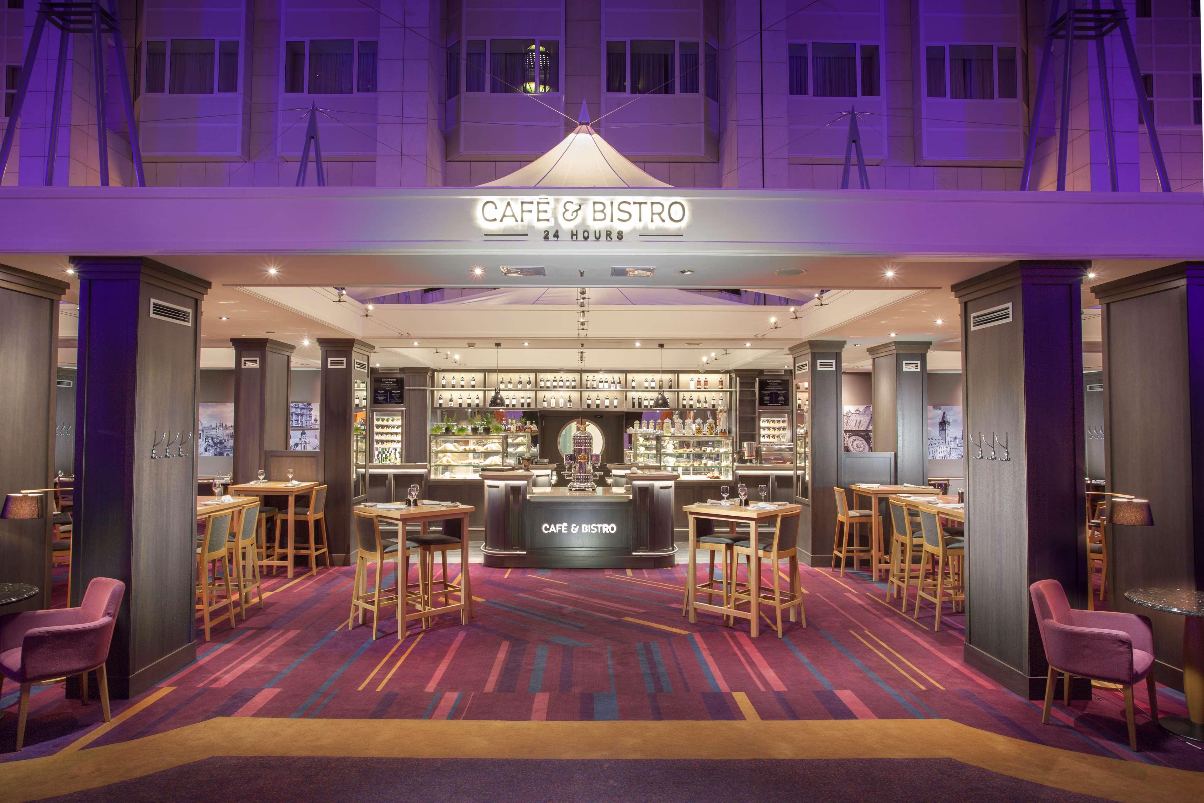 Hilton Prague Hotel Exterior foto The photo shows a modern café and bistro establishment. The interior features a well-lit bar area with shelves stocked with various beverages, highlighted by pendant lights. There are several high-top tables and chairs arranged around the space, prov